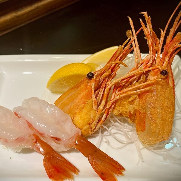 Edomasa Sushi Bar & Restaurant's fried shrimp heads and shrimp nigiri with lemon wedges.