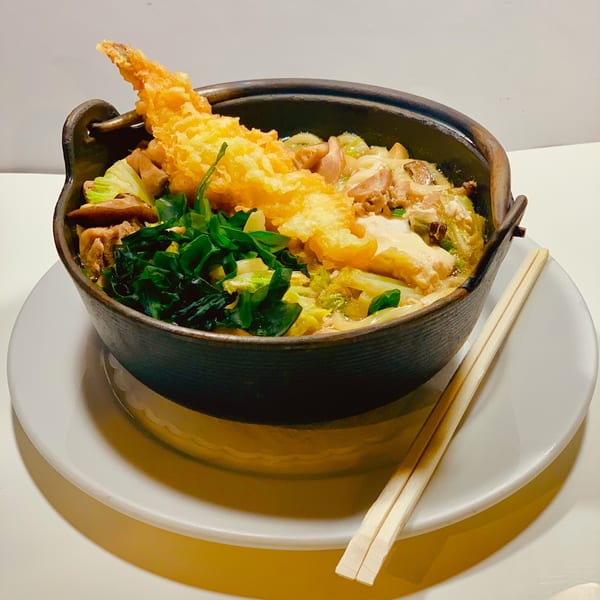 Edomasa Sushi Bar's Japanese hot pot with tempura, vegetables, and meat, served with chopsticks.